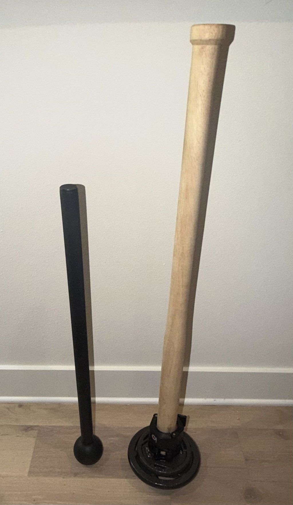 A buyer's phone photo of the wooden EZ-MACE PRO standing on a plate next to a fixed steel mace