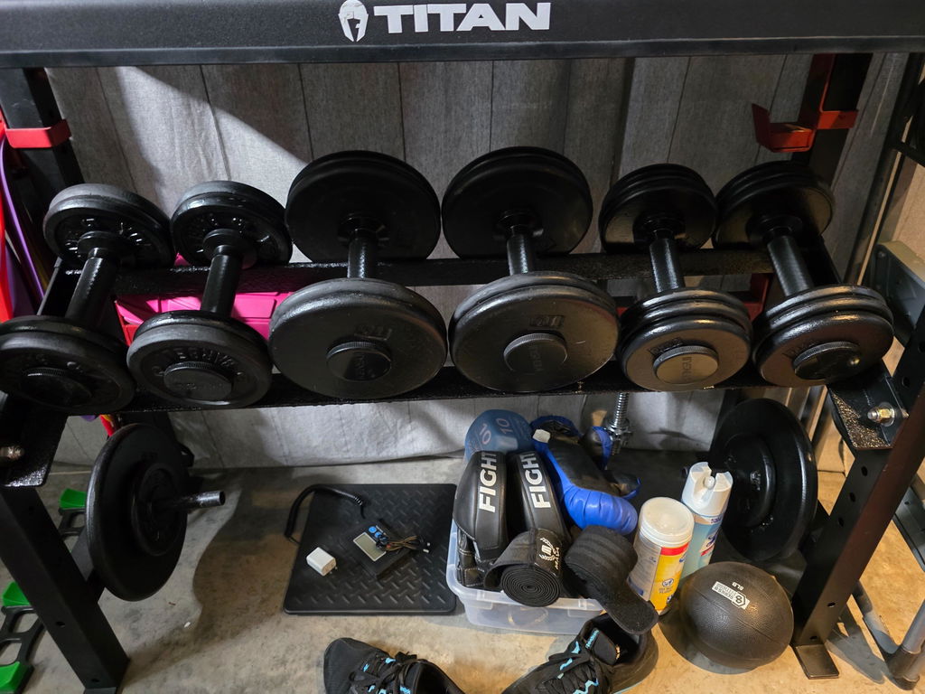 Loaded adjustable dumbbell handle on a home gym floor
