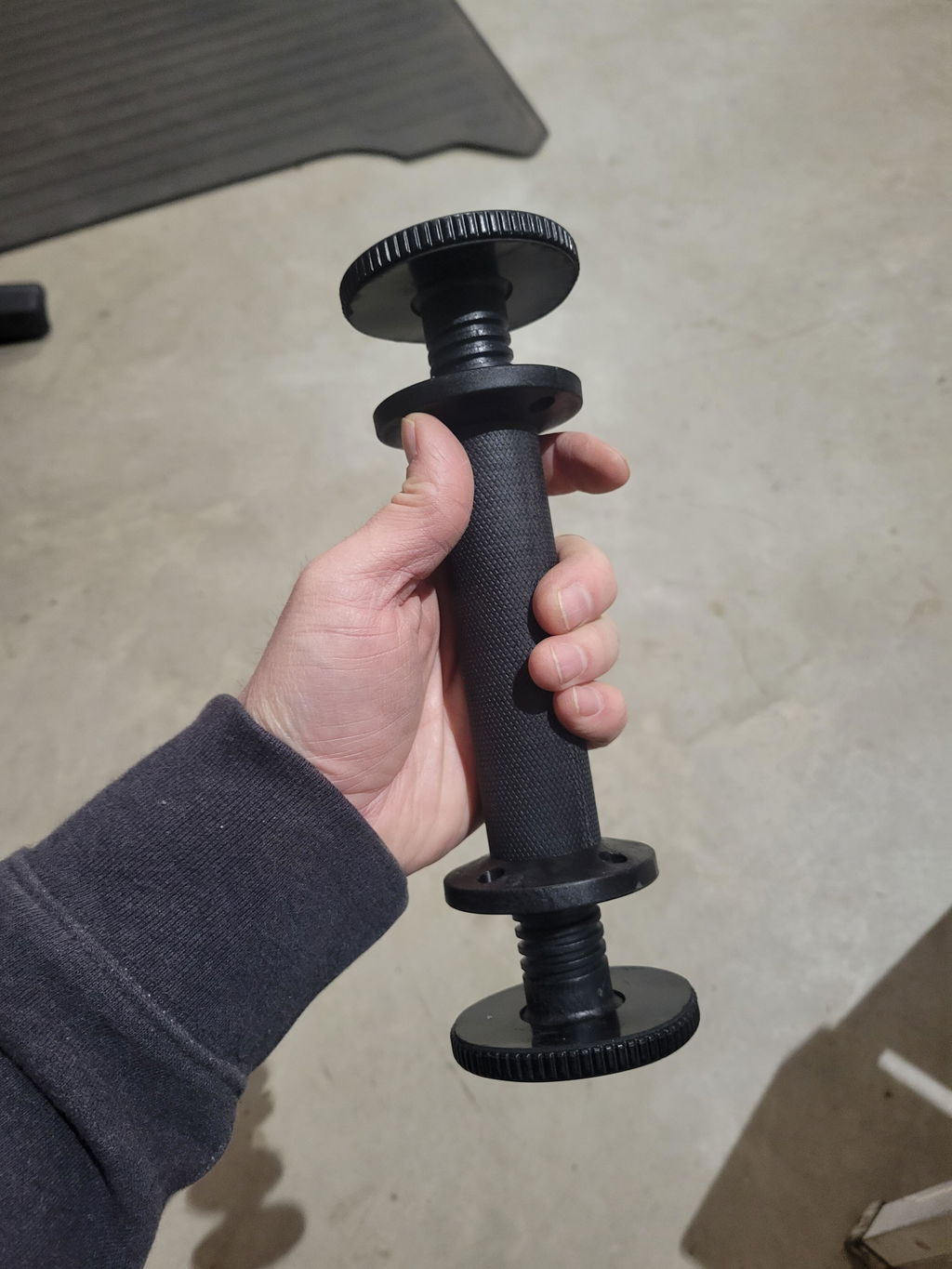 Bare adjustable dumbbell handle held in one hand