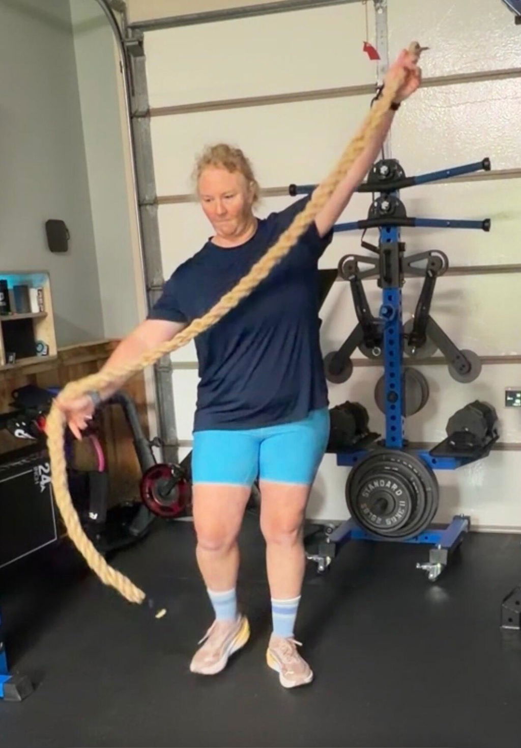 Lifter holding a training rope in a garage gym