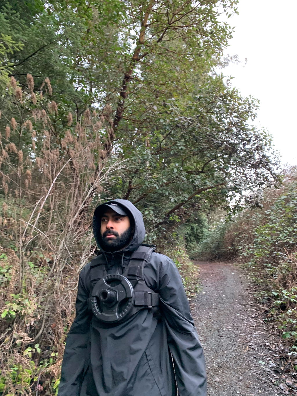 Hiker on a trail wearing a loaded weight vest under a jacket