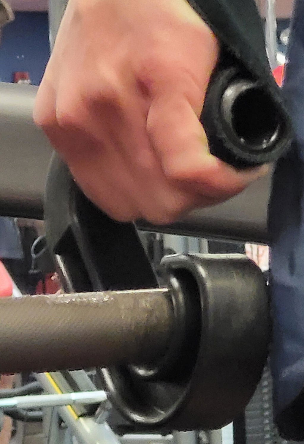 Hand gripping a neutral-grip pull-up handle mounted on a bar